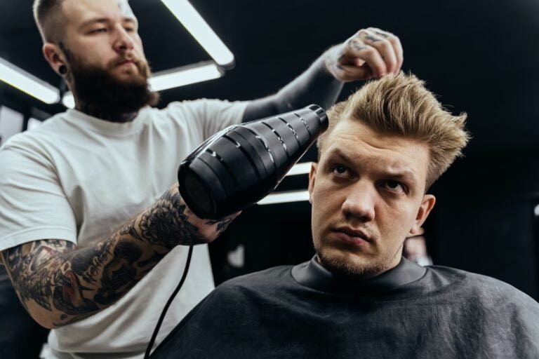 Peluquero secando cabello masculino en peluquería